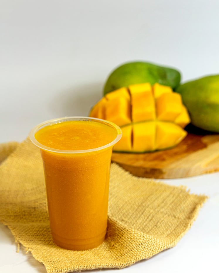 Fresh mango juice in a plastic cup. Healthy drink