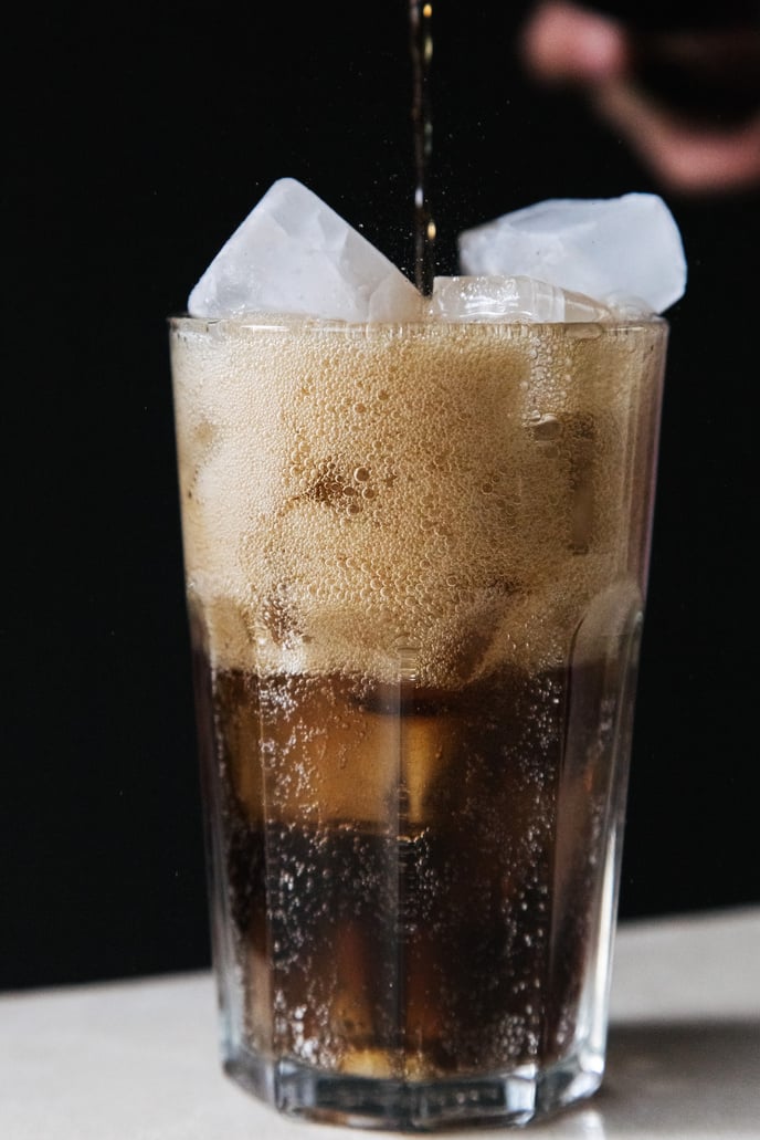 A Cola on a Drinking Glass with Ice Cubes